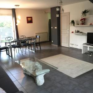 uma sala de estar com uma mesa de vidro e cadeiras em La Villa W’ILLYS em Montpellier