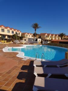 duży basen z krzesłami w ośrodku w obiekcie HATO Holiday Home Fuerteventura w mieście Costa Calma