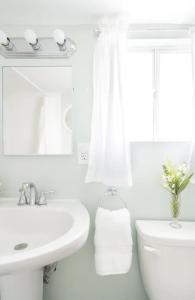a white bathroom with a sink and a toilet at Upgrade Rosarito Seaside Guest House with Beach Access in Rosarito