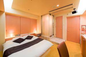 a bedroom with a large bed with orange cabinets at Osaka - Hotel / Vacation STAY 70127 in Osaka