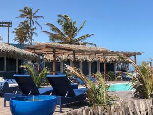 un complejo con sillas azules y piscina en Cabana Chic Sunrise en Tatajuba