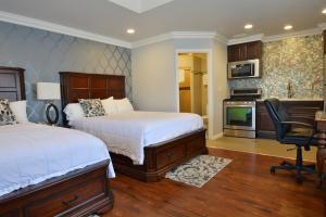 a bedroom with two beds and a desk and a chair at Crystal Lodge Motel in Ventura