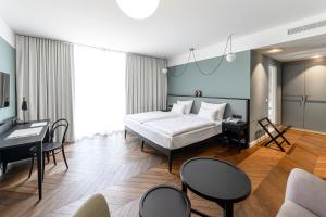 a bedroom with a bed and a desk and chairs at Hotel Caroline in Vienna