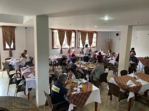 薩帕托卡的住宿－Hotel Abadias De Zapatoca，一群坐在餐厅桌子上的人