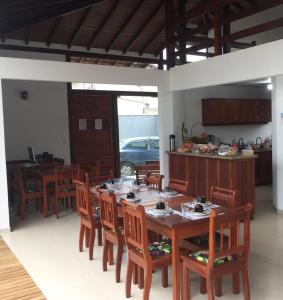 a dining room with a table and chairs and a kitchen at Pouso Alcantara in Paraty