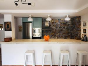 a kitchen with a counter with four stools in it at Mirador del Lago in Córdoba