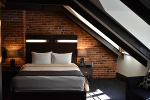 a bedroom with a bed in a brick wall at Hôtel Sainte-Anne in Quebec City