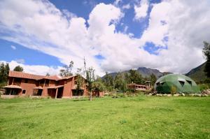 una tienda verde en un campo junto a una casa en Kinsapacha Eco Lodge Farm en Urubamba