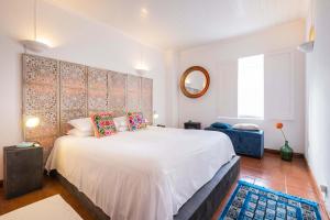 a bedroom with a large white bed with pillows at epicenter ORIENT in Ponta Delgada