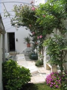a garden with pink flowers and a table and chairs at Villa Fleur de Sel in Fouras
