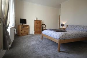 a bedroom with a bed and a dresser and a television at Paull Holme Farm Bed and Breakfast in Paull +9 photos