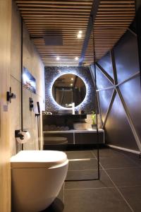 a bathroom with a toilet and a round mirror at Mirror Glamping in Sesquilé