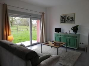uma sala de estar com um sofá e uma mesa em La gaîté de louvignies em Louvignies-Quesnoy