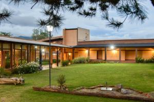 uma casa com um grande relvado em frente em Hostería El Remanso em El Mollar