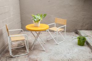 a yellow table and two chairs and a plant at CÓMODO DEPARTAMENTO EN ZONA CÉNTRICA in Rafaela
