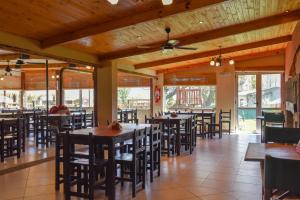 a dining room with tables and chairs and windows at Hostería El Remanso in El Mollar