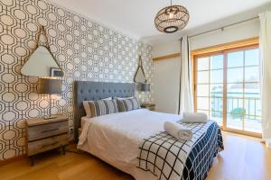 1 dormitorio con cama y ventana grande en Carcavelos Beach, en Carcavelos