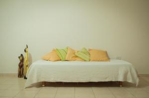 a bed with orange and green pillows and a guitar at CÓMODO DEPARTAMENTO EN ZONA CÉNTRICA in Rafaela +6 photos