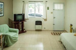 a living room with a tv and a bed and a window at CÓMODO DEPARTAMENTO EN ZONA CÉNTRICA in Rafaela