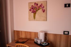 a wooden table with a flower painting on the wall at Villa Lucin in Pinzolo