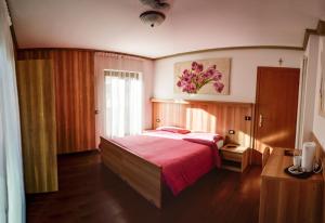 a bedroom with a large bed with a red blanket at Villa Lucin in Pinzolo