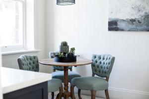 a dining room table with chairs and a cactus on it at Old Market Inn in Port Fairy