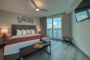 Un dormitorio con una cama con una bandeja de comida. en FUSION Resort Two Bedroom Suites, en St Pete Beach