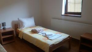 a small bedroom with a bed with towels on it at Apartmani Gmitrovic in Rtanj