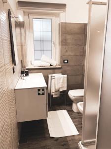 een badkamer met een wastafel, een toilet en een raam bij Caput Mundi Anagnina III in Rome