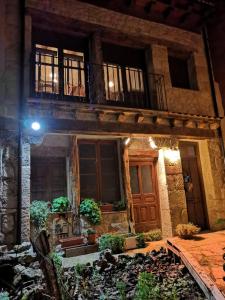 kamienny dom z drewnianymi drzwiami i balkonem w obiekcie Casa Rural LA FUENTONA w mieście Valle de Tabladillo