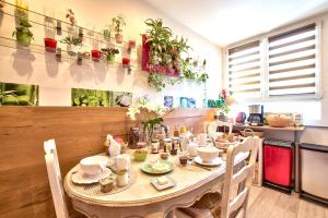 una mesa con sillas y una mesa con plantas en la pared en NATURALBNB - Chambres d'hôtes au calme avec clim - Parking gratuit et sécurisé - Garage vélos et motos - Super petit déjeuner fait maison ! en Villeurbanne