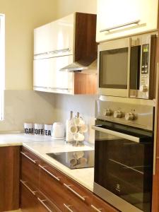 a kitchen with a stove and a microwave at The Village Apartment 2 in Kirkop