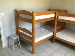 Ce dortoir comprend 2 lits superposés et un tabouret. dans l'établissement Maison bercée par le bruit de la mer île de ré, à Sainte-Marie de Ré
