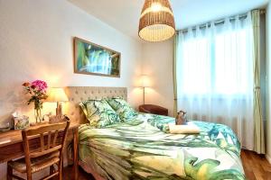 a bedroom with a bed and a desk and a table and chair at NATURALBNB - Chambres d'hôtes bios, éthiques - Au calme, confort dans résidence fermée - PARKING GRATUIT, SECURISE - Garage vélos et motos - OFFERT SUPER PETIT DEJEUNER local et bio sucré salé in Villeurbanne