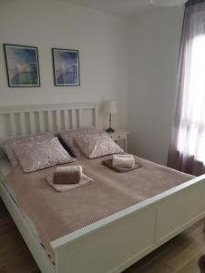 un grande letto bianco con due cuscini sopra di Apartman Viktoria a Tuzla