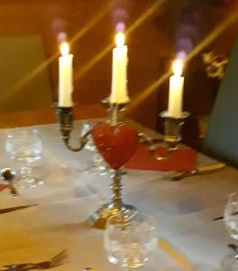 a table with two candles and a heart in a vase at Chalet TERRA LOUP in Le Dévoluy