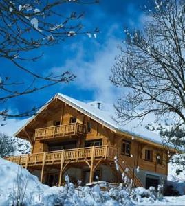 ル・デヴォリュイにあるChalet TERRA LOUPの雪の大木造家屋
