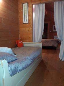 ル・デヴォリュイにあるChalet TERRA LOUPの木造キャビン内のベッド1台が備わるベッドルーム1室を利用します。