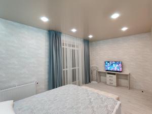 a bedroom with a bed and a flat screen tv at Yarovytsya VIP in the CENTER in Luts'k