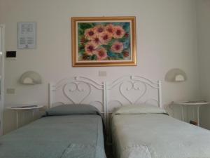 two beds sitting next to each other in a bedroom at Hotel Signorini in Castiglioncello