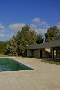 a building with a swimming pool in front of it at Casas en Barrio Los Teros con pileta compartida - Santa Clara del Mar in Santa Clara del Mar