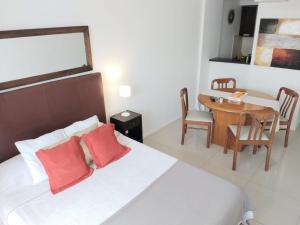 Un dormitorio con una cama con almohadas rojas y una mesa. en Abasto Gardel Tango, en Buenos Aires