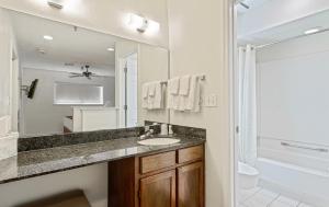 ein Badezimmer mit einem Waschbecken und einem großen Spiegel in der Unterkunft Chase Suite Hotel Rocky Point Tampa in Tampa
