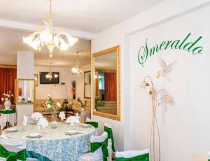 イーゾラ・ロッサにあるHotel Smeraldoのダイニングルーム(テーブル、緑の椅子付)