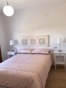 Un dormitorio con una cama con dos mesas y dos lámparas. en APARTAMENTOs IGLESIA DE SANTIAGO, en Jerez de la Frontera
