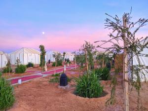 a garden with many greenhouses with trees and plants at Sahara Majestic Luxury Camp in Merzouga