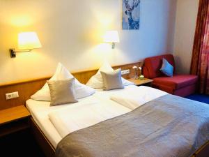 Habitación de hotel con cama y silla roja en Hotel Austria Stuttgart-City en Stuttgart