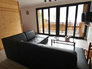 a living room with a couch and a table at Chalet les Ombrettes in Ceillac