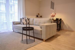 a living room with a white couch and a table at Apartamenty na Wyspie - Villa Pegaz - Parking in Świnoujście