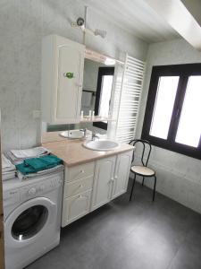 a bathroom with a washing machine and a sink at Chalet les Ombrettes in Ceillac